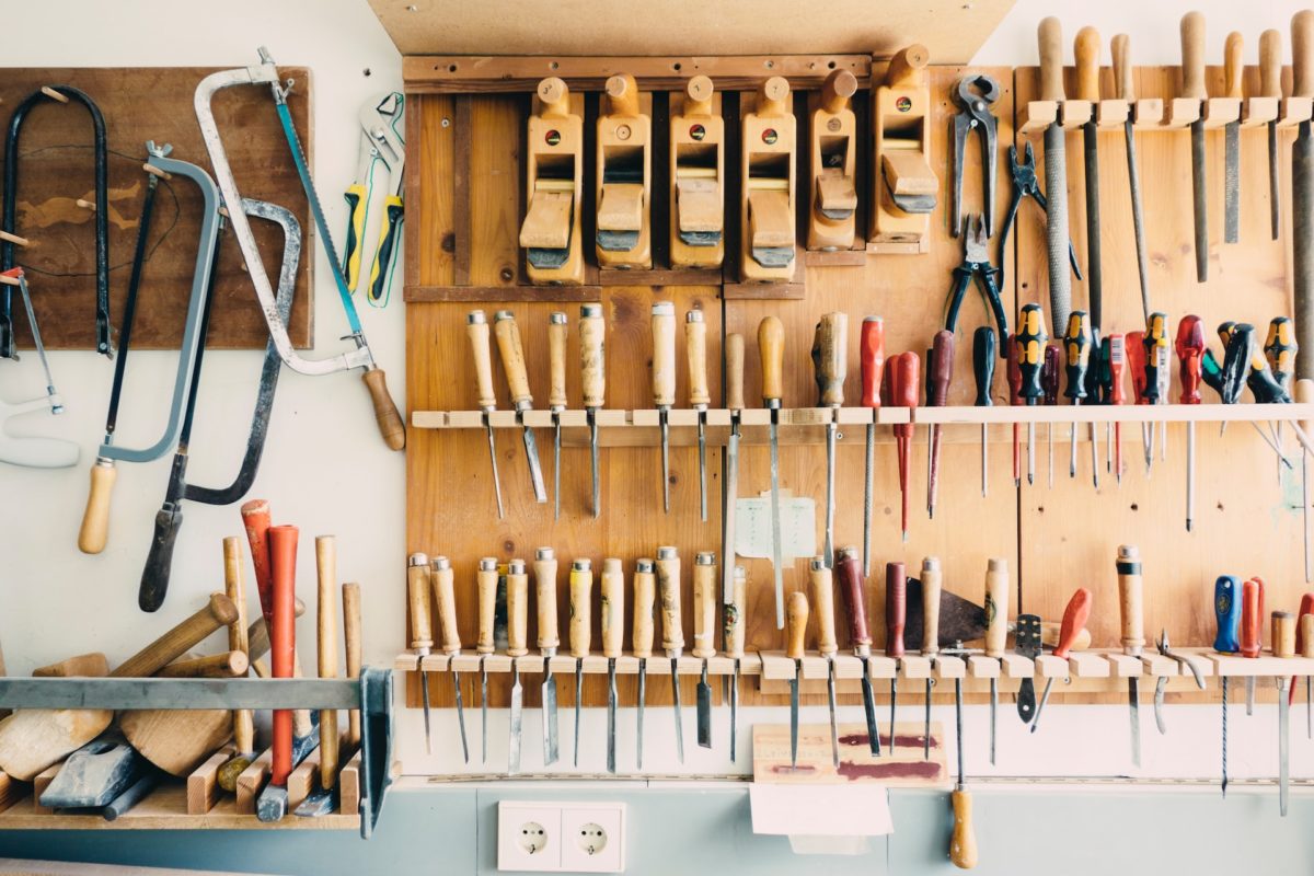 A range of tools displayed on shelving in a barn